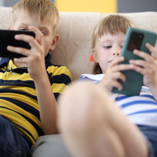 To børn kigger på smartphones