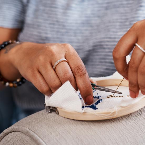 Nærbillede af broderende hænder