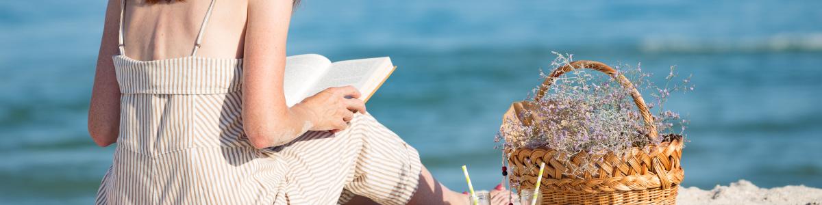 Kvinde der læser på en strand